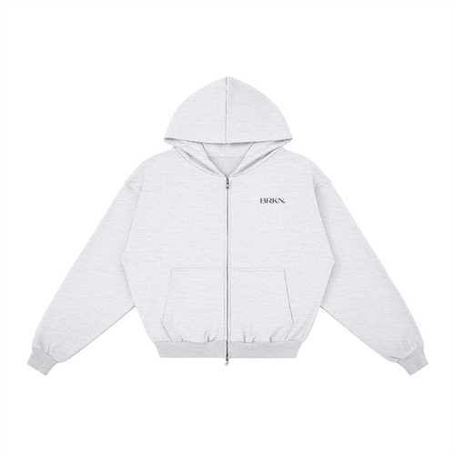 Light gray zip-up hoodie with BRKN. logo, minimalist streetwear design, front pocket, hooded sweatshirt